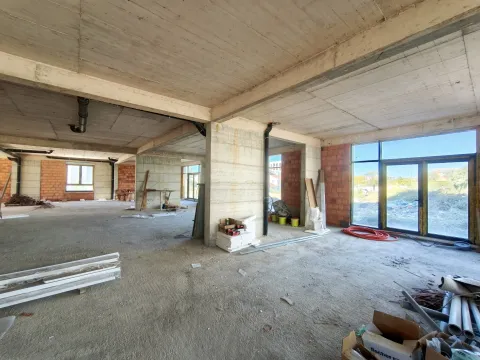 Unfinished space under construction with concrete pillars and large windows. - image 2