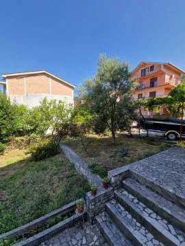 Pogled na dvorište sa zelenilom i kamenim stepeništem ispred kuće. - image 8