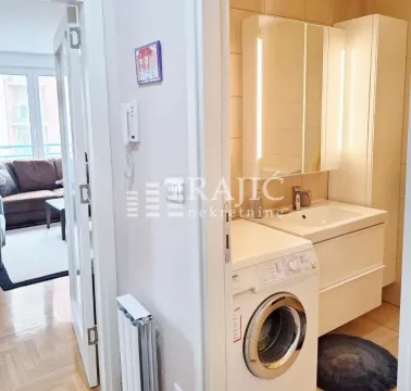 Smaller bathroom with a sink, mirror, and washing machine. - image 12