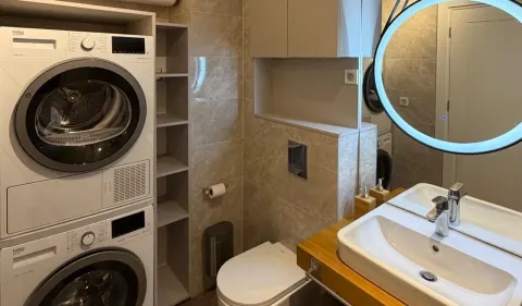 Kupatilo opremljeno umivaonikom, WC šoljom i ugrađenom mašinom za pranje i sušenje veša. - image 4