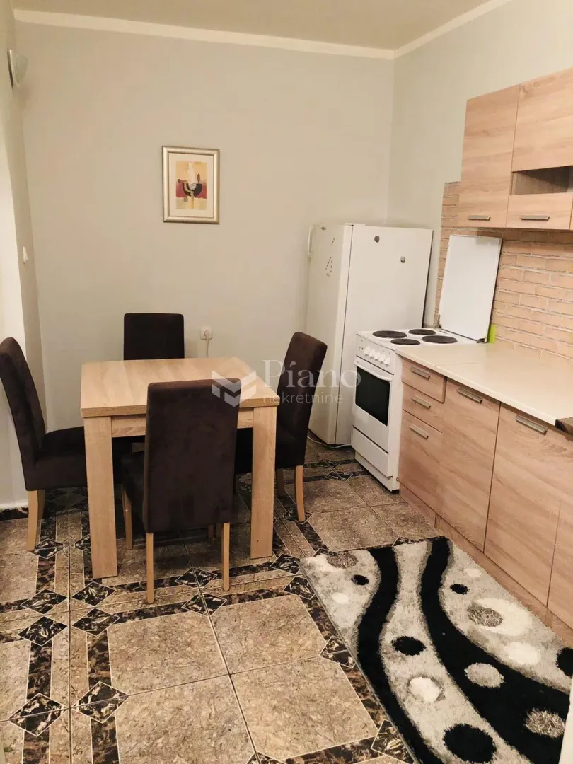 Kitchen with dining area and wooden units.