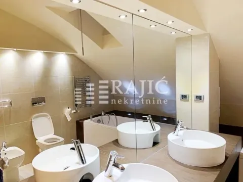 Modern bathroom with two sinks, a bathtub, and recessed lighting. - image 12