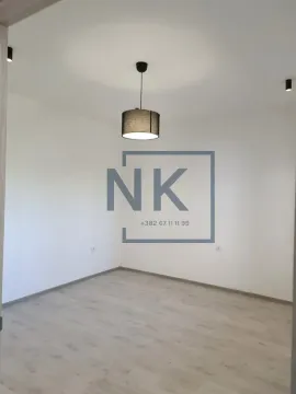 Empty room with white walls, laminate flooring, and a ceiling pendant light. - image 3