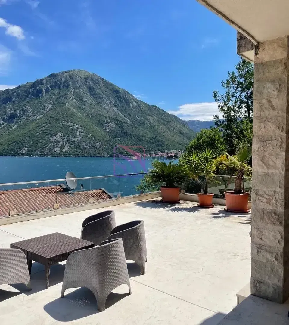 Prostrana terasa sa garniturom za sjedenje i pogledom na more i planine.