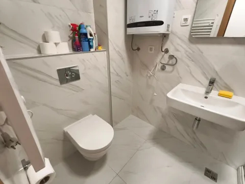 Moderno opremljeno kupatilo sa bijelim pločicama i ugradnim elementima. - image 4