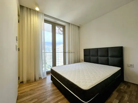 Modern bedroom with a double bed and large balcony doors. - image 5