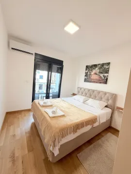 Uređena spavaća soba sa bračnim krevetom i izlazom na terasu. - image 6