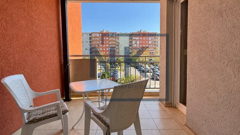 Covered balcony with outdoor seating and a view of the neighborhood.