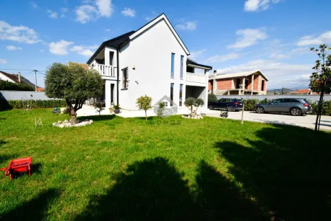 View of the yard and the exterior of the house with a manicured lawn. - image 3