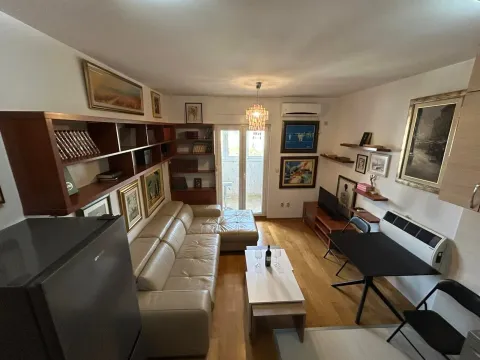 Living room furnished with a sofa, bookshelf units, and a dining table. - image 14