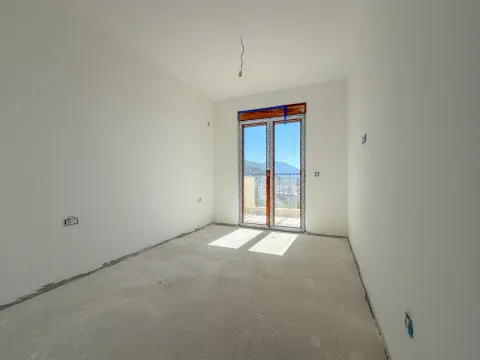 Prazna prostorija u sivoj fazi sa balkonskim vratima i pogledom na okolinu. - image 7