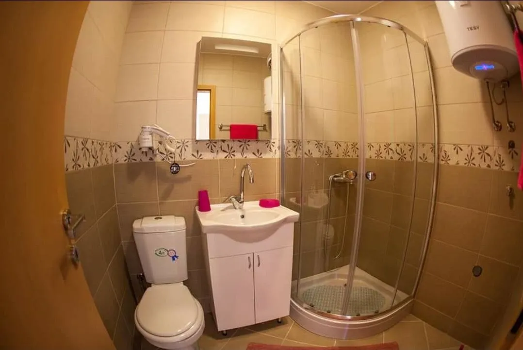Small bathroom with a shower cabin, sink, and toilet.