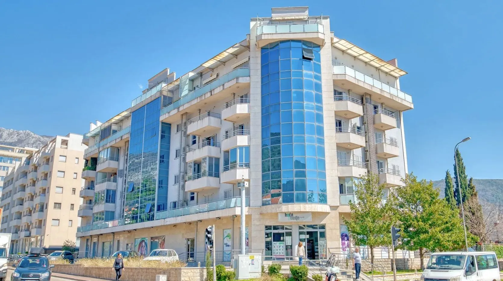 Exterior view of a modern residential building with a glass facade and balconies.