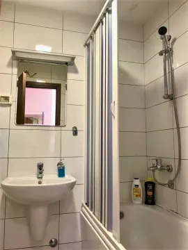 Jednostavno kupatilo sa kadom, tušem i umivaonikom sa ogledalom. - image 7