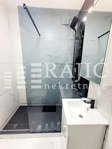 Modern bathroom with a walk-in shower and a vanity unit.