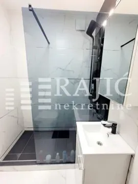 Modern bathroom with a walk-in shower and a vanity unit. - image 13