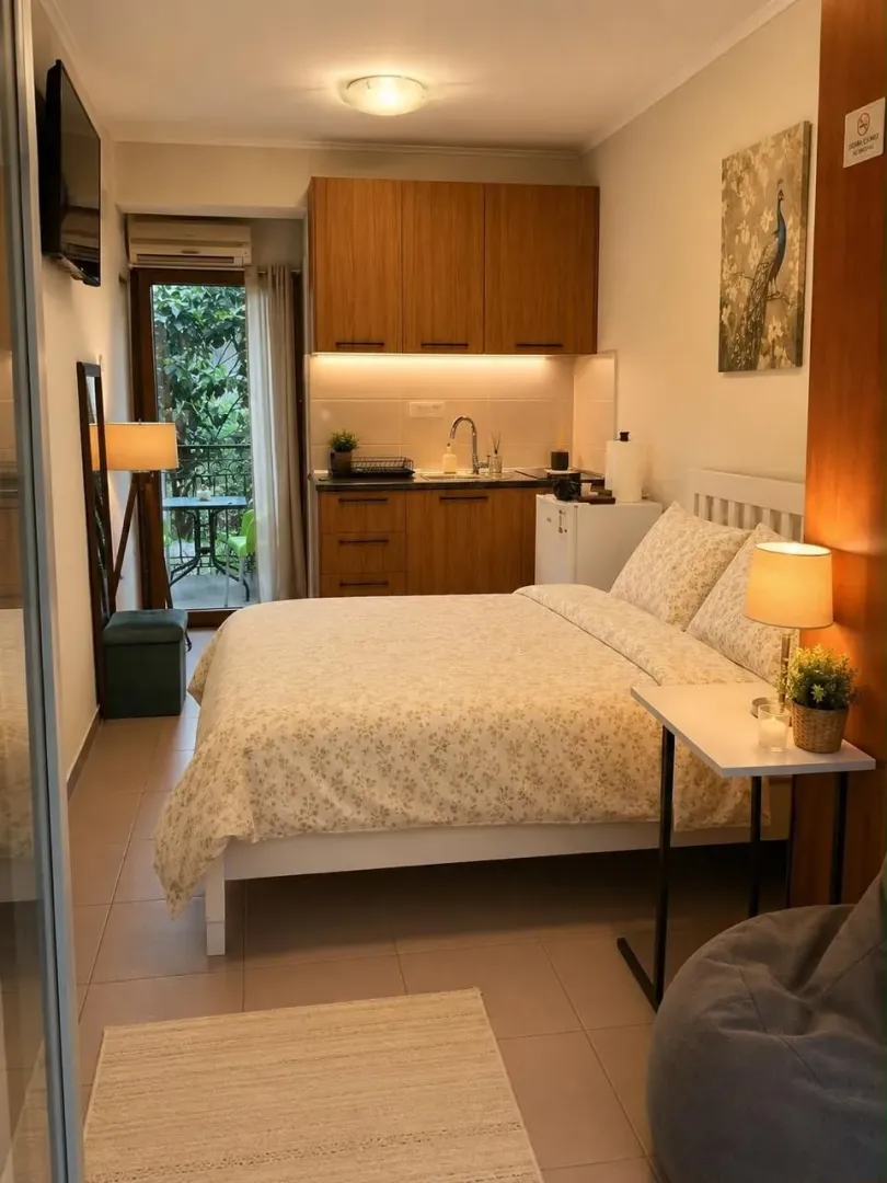 Furnished bedroom with a double bed and kitchen units in the corner.