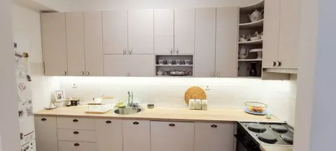 Kuhinja sa svijetlim elementima, radnom pločom u boji drveta i ugradnim uređajima. - image 2