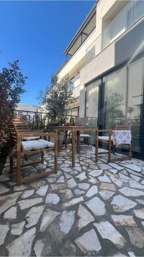 Terrace with a wooden table and chairs in front of the house.