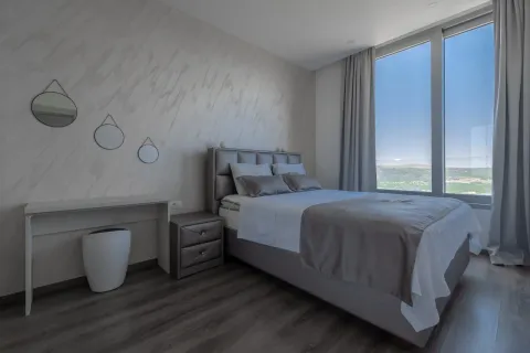 Modern bedroom with a double bed, a desk, and a large window. - image 3
