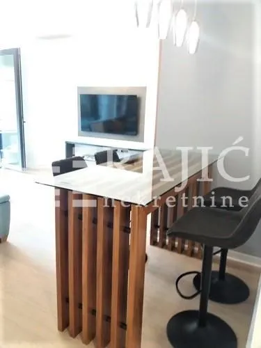 Living room with a dining table and modern lighting.
