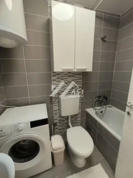 Bathroom equipped with a bathtub, toilet, and washing machine. - image 8