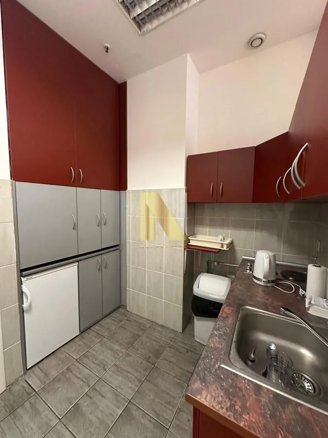 Small kitchen with dark red and grey cabinets and a sink.
