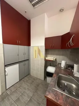 Small kitchen with dark red and grey cabinets and a sink. - image 10