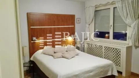 Spavaća soba sa velikim bračnim krevetom i drvenim uzglavljem. - image 11