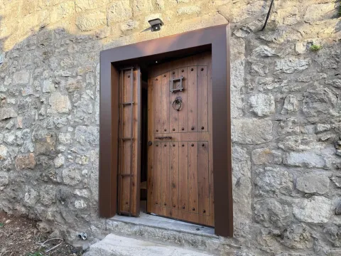 Drvena ulazna vrata na kamenoj kući. - image 3