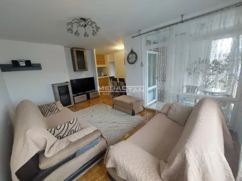 Dnevna soba sa garniturom, televizorom i izlazom na terasu. - image 2