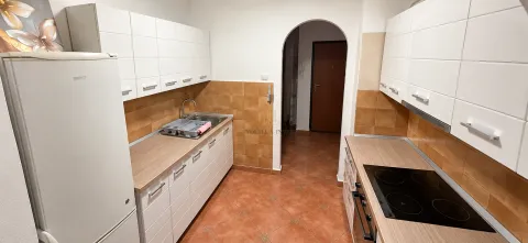 Kuhinja sa bijelim elementima, frižiderom i ugrađenom pločom za kuvanje. - image 4