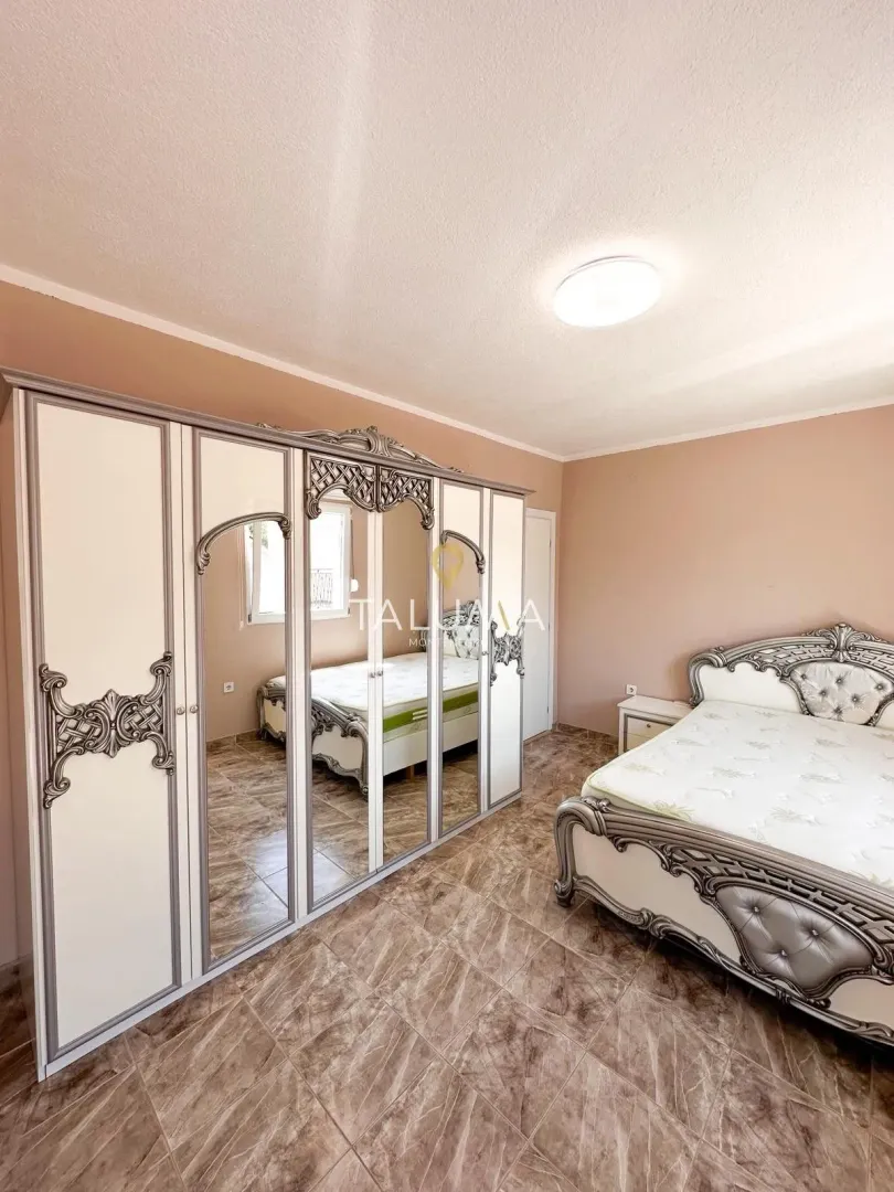 Spacious bedroom with a large double bed and wardrobe.