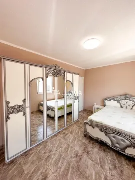Spacious bedroom with a large double bed and wardrobe. - image 12