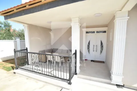 Covered terrace in front of the house entrance with seating furniture. - image 3