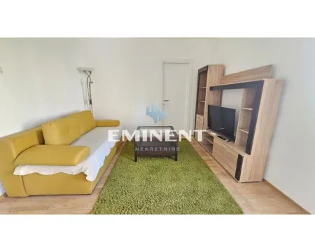 Living room with a yellow sofa, TV unit, and a rug. - image 2