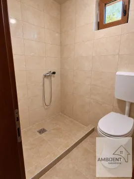 Kupatilo obloženo keramičkim pločicama sa tuš kabinom i toaletom. - image 10