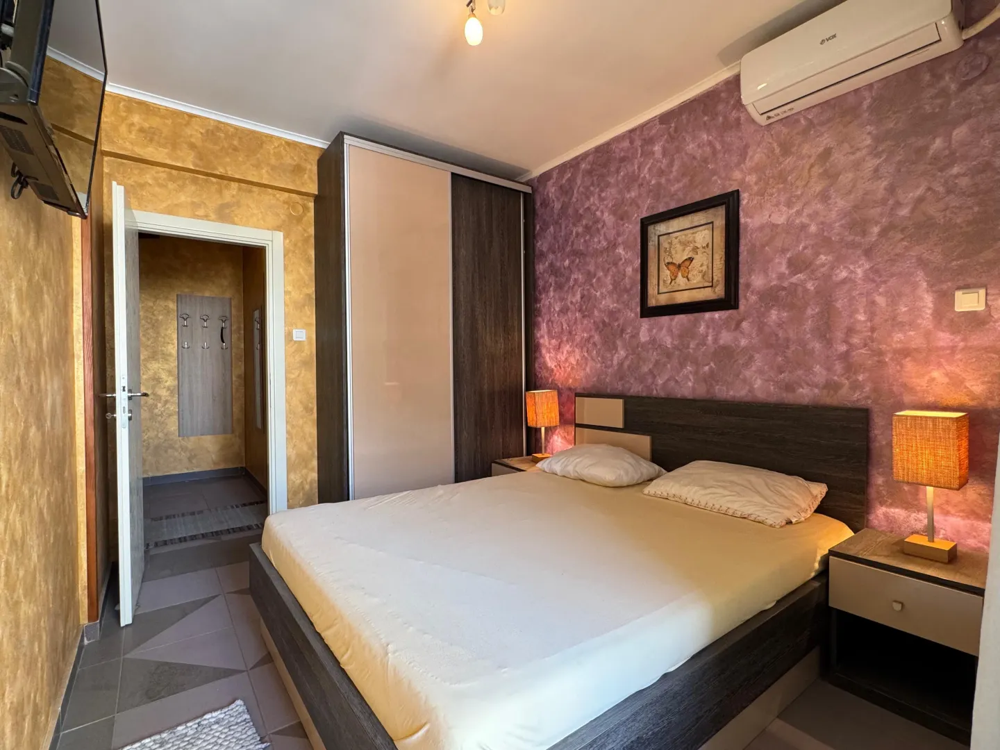 Furnished bedroom with a double bed, wardrobe, and decorative lighting.