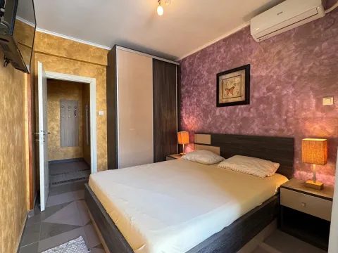 Furnished bedroom with a double bed, wardrobe, and decorative lighting. - image 12