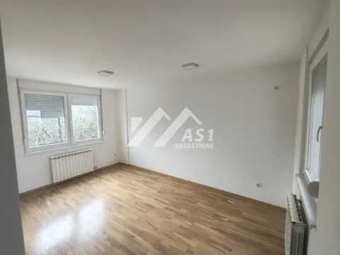 Prazna soba sa parketom, belim zidovima i dva prozora. - image 4