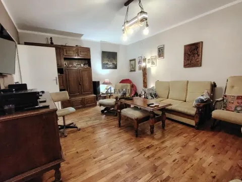 Dnevni boravak sa garniturom za sedenje i drvenim nameštajem. - image 2
