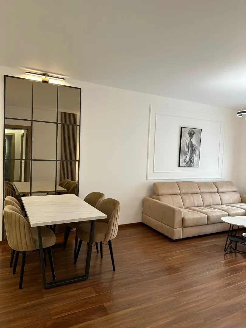Living room with dining area, sofa and large mirror.