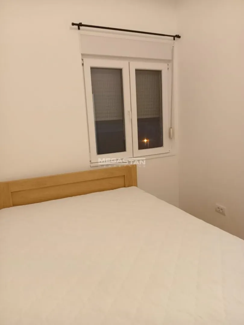 Spavaća soba sa bračnim krevetom i prozorom.