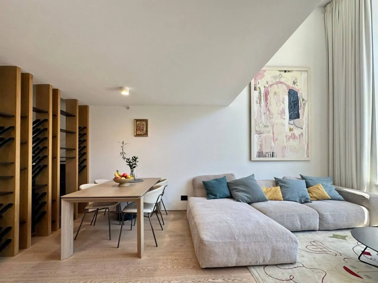 Living room with dining area, sofa set, and wooden shelving.