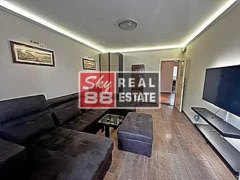 Living room with a sectional sofa, television, and wooden flooring. - image 5