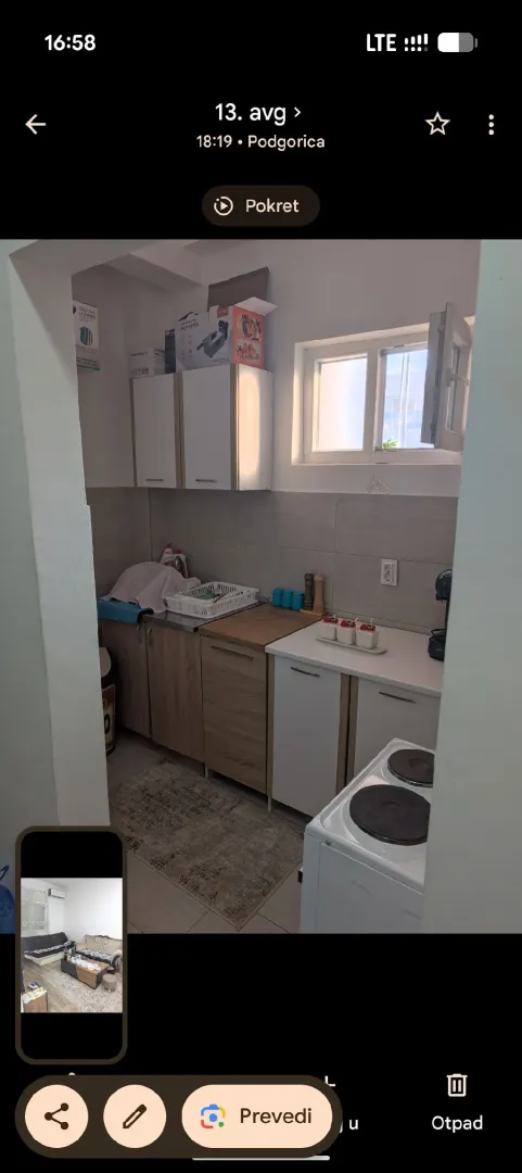 Small kitchen with wood-patterned cabinets and white goods.