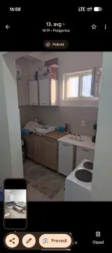 Small kitchen with wood-patterned cabinets and white goods. - image 2