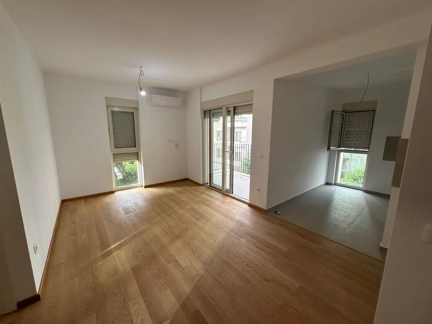 Empty room with wooden flooring and access to a terrace.