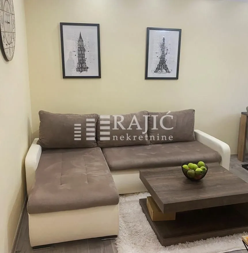 Living room with a sectional sofa, coffee table, and wall art.