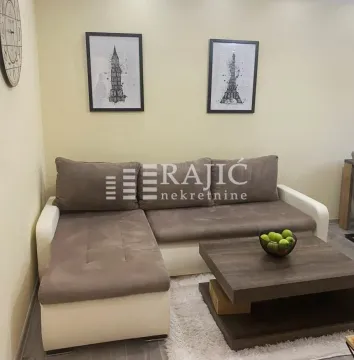 Living room with a sectional sofa, coffee table, and wall art. - image 3